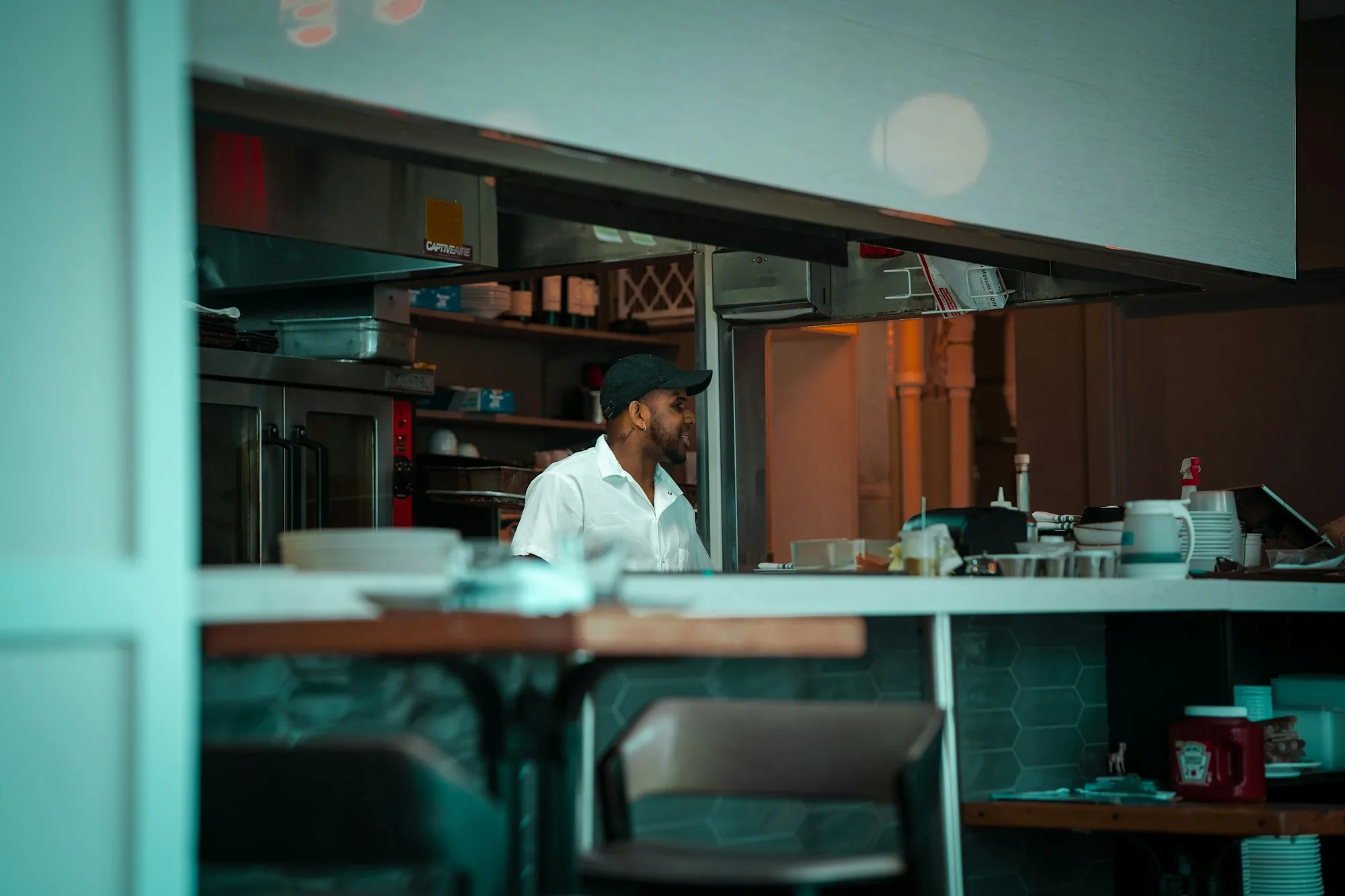 A chef working behind the pass in a restaurant kitchen