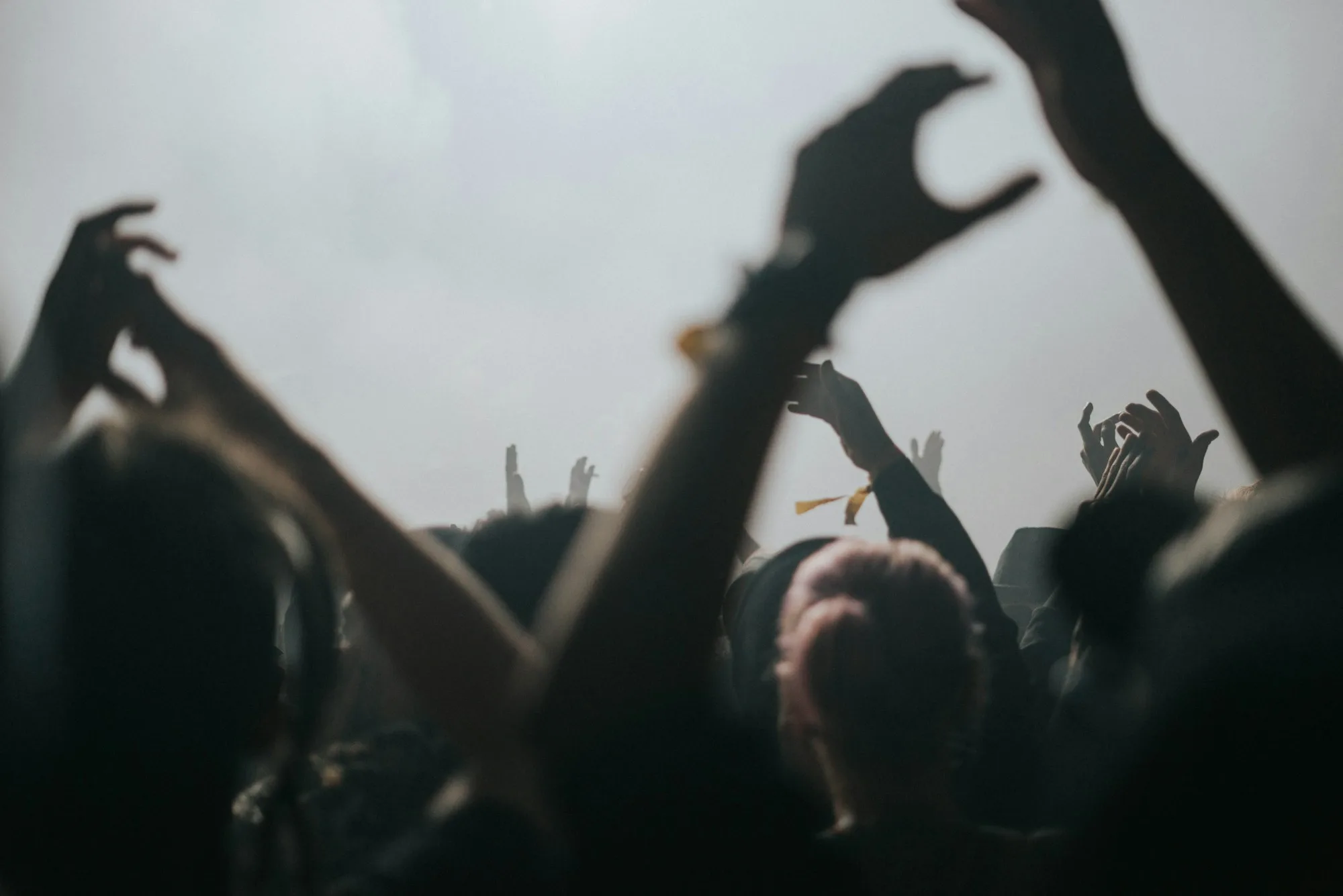 Crowd moving through light and fog at a live event