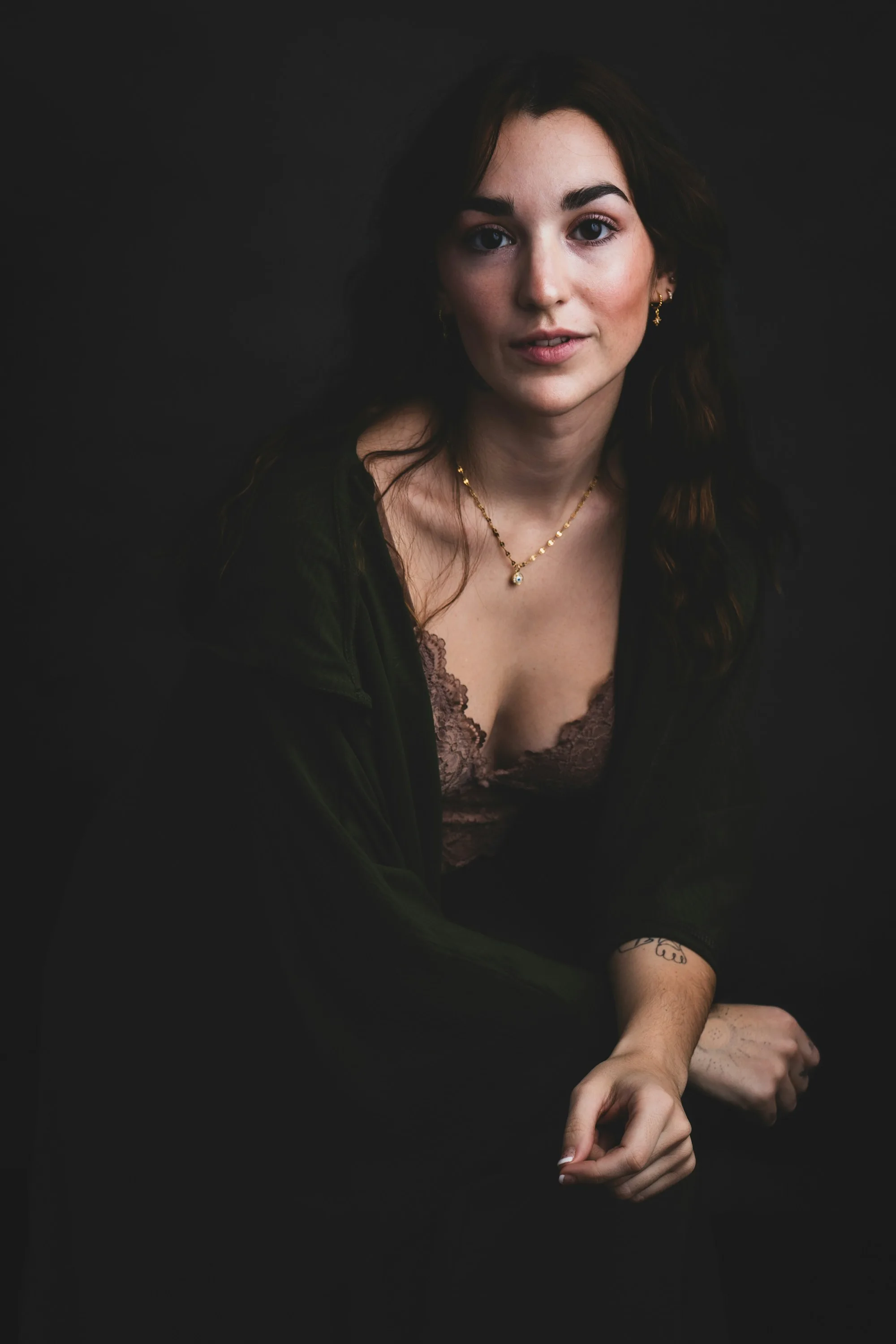 A woman photographed against a dark studio background